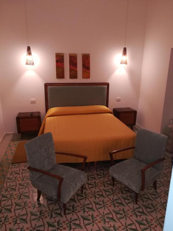 a bedroom with a bed and two chairs at MandorleOlio in Polignano a Mare