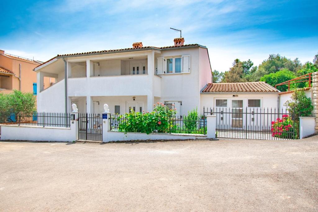 a white house with a black fence at Apartments Betty in Rovinj