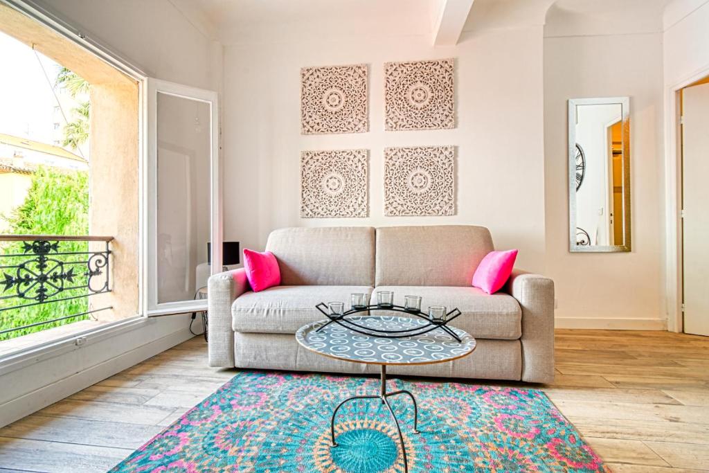 un salon avec un canapé et une table dans l'établissement Romantic and new apartment in the famous Rue Meynadier in the supercentre of Cannes, à Cannes