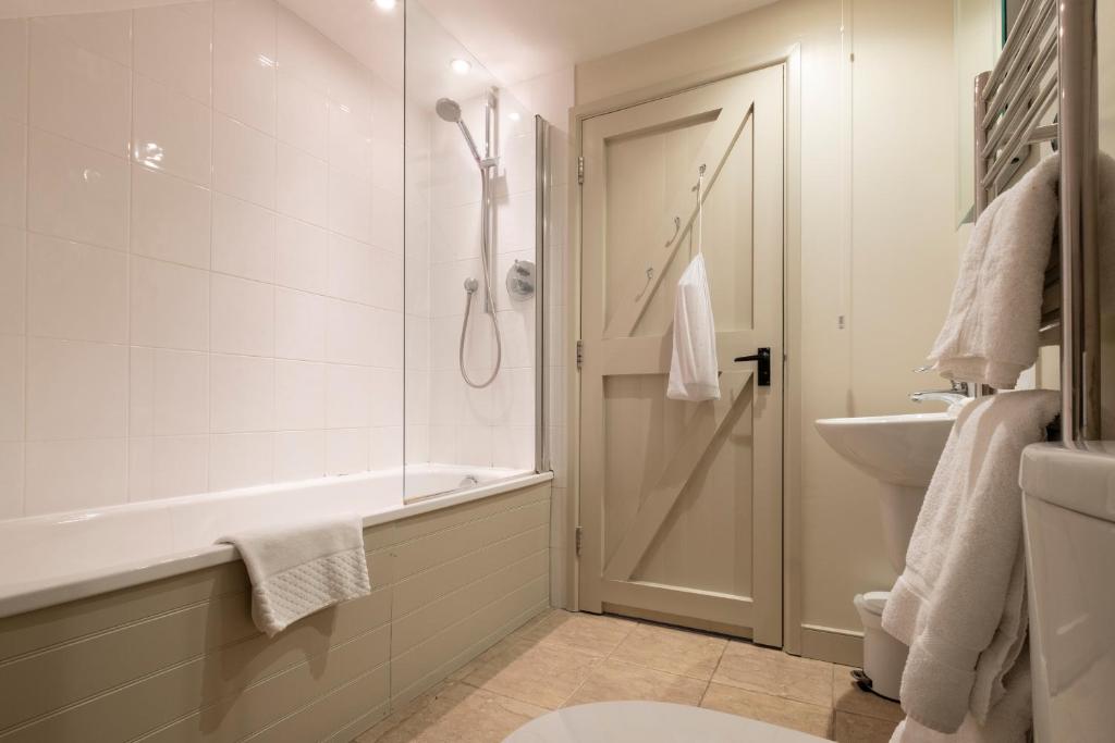 a bathroom with a shower and a tub and a sink at The Ship At Dunwich in Dunwich