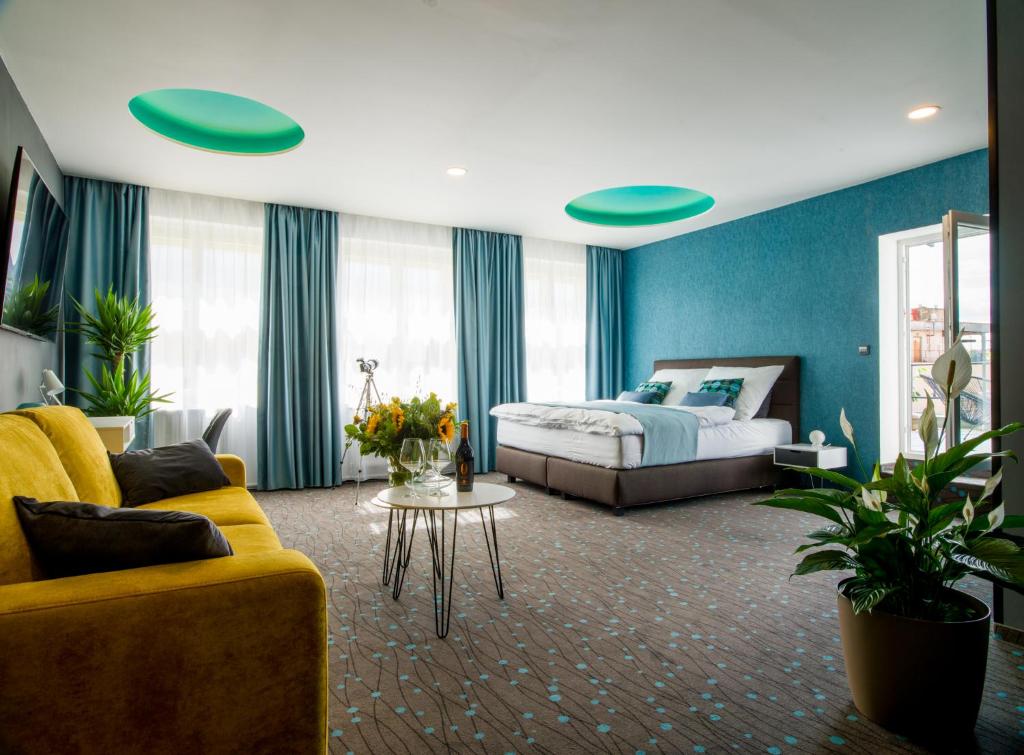 een slaapkamer met een bed, een bank en een tafel bij Rooftop Planet Prague Hotel in Praag