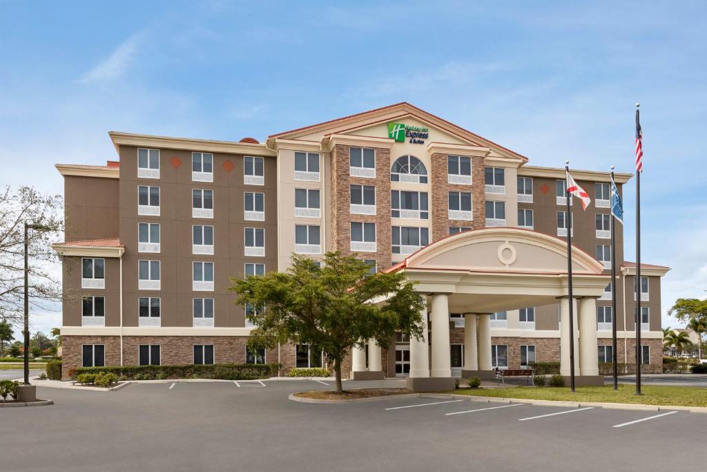 uma imagem de um edifício de hotel com estacionamento em Holiday Inn Express Hotel & Suites Fort Myers East - The Forum, an IHG Hotel em Fort Myers