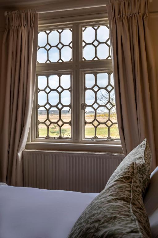 a bedroom with a window and a bed with a pillow at The Ship At Dunwich in Dunwich