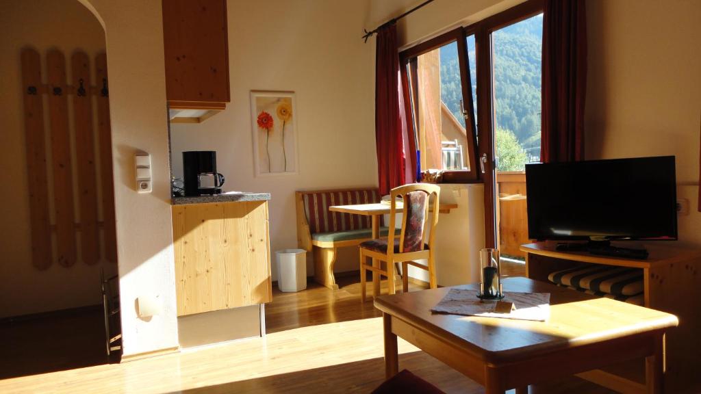 uma sala de estar com uma mesa e uma televisão em Ferienwohnungen Birnbacher em Sankt Ulrich am Pillersee