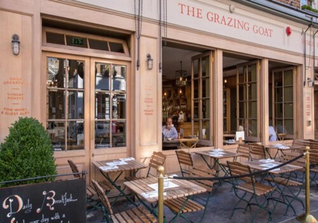 um grupo de mesas e cadeiras fora de um restaurante em The Grazing Goat em Londres