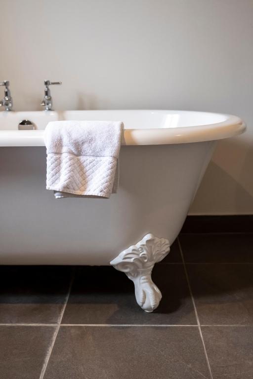 a bathroom with a white bath tub and a sink at The Ship At Dunwich in Dunwich
