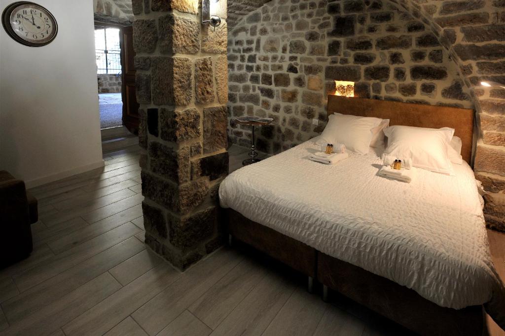 a bedroom with a bed in a brick wall at Chambre Comballe charmante avec jacuzzi in Sanilhac