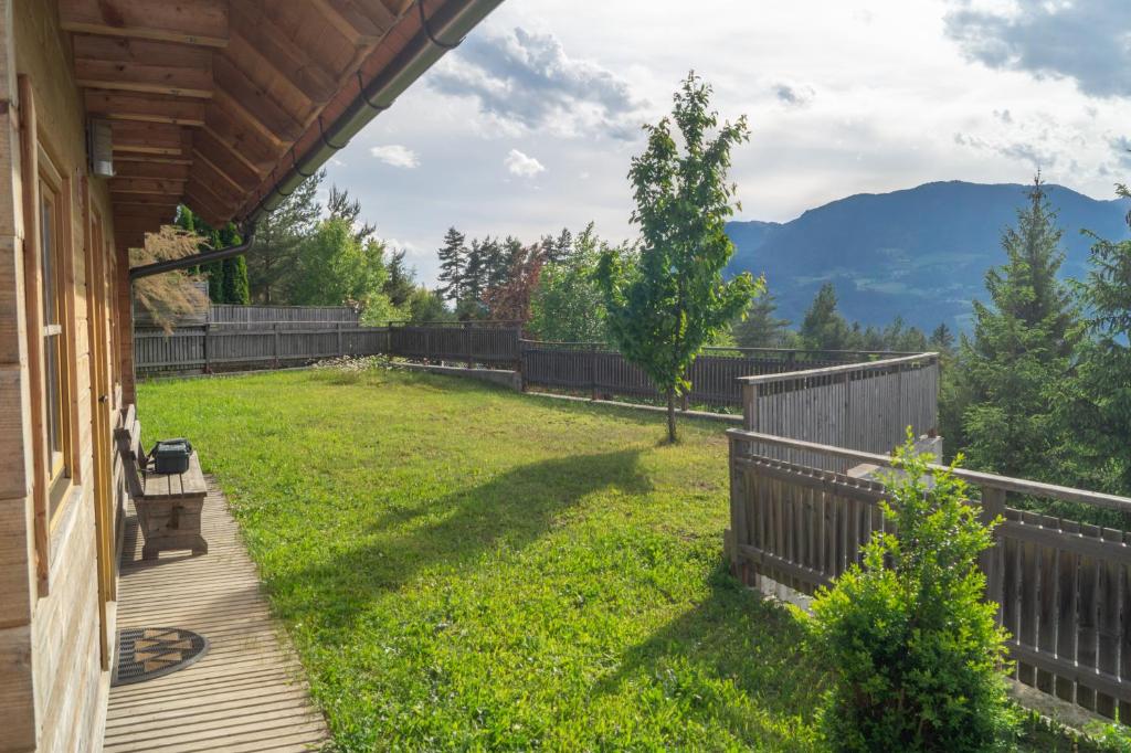 a backyard with a wooden fence and a grass yard at house on the top of the hill in Mozirje