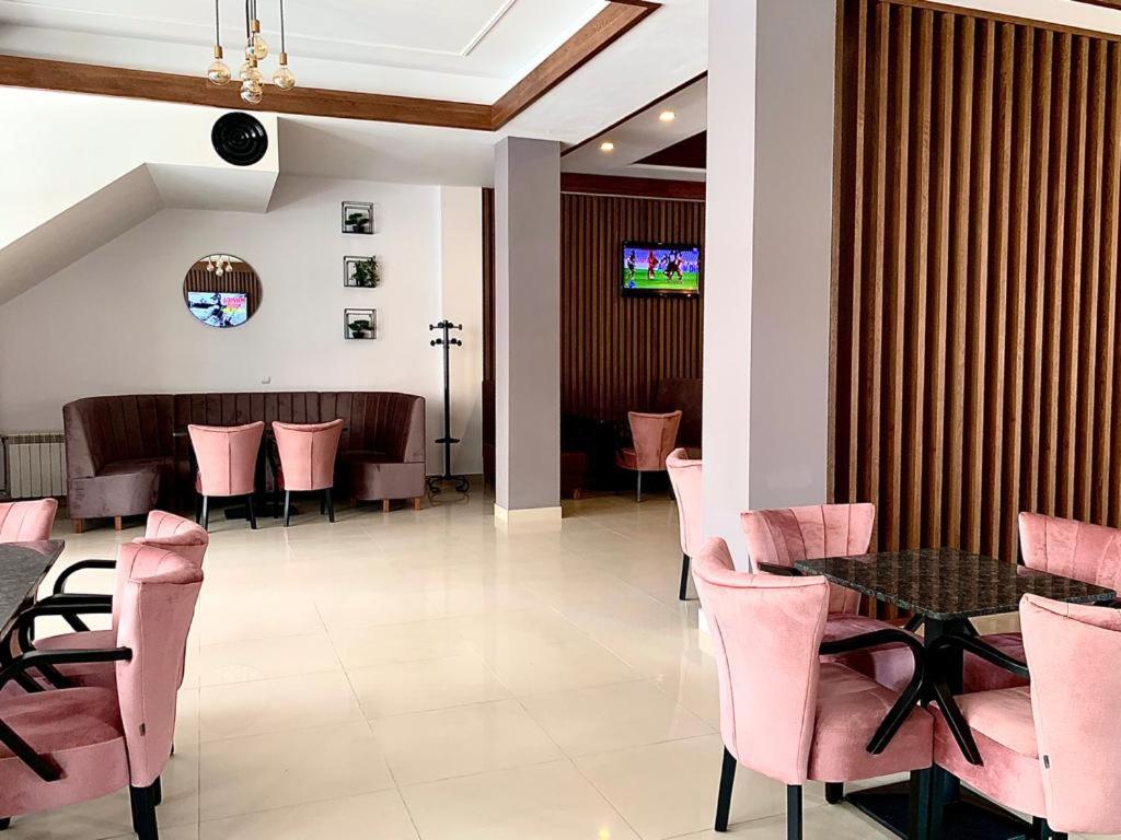 a dining room with pink chairs and a table at Pensiunea OK in Vişeu de Sus