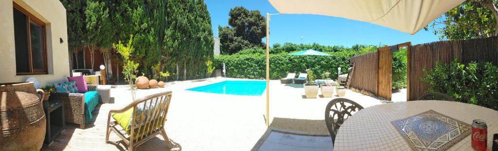 a patio with a table and chairs and a pool at Casa Francesca Altea piscina y aparcamiento privado in Altea