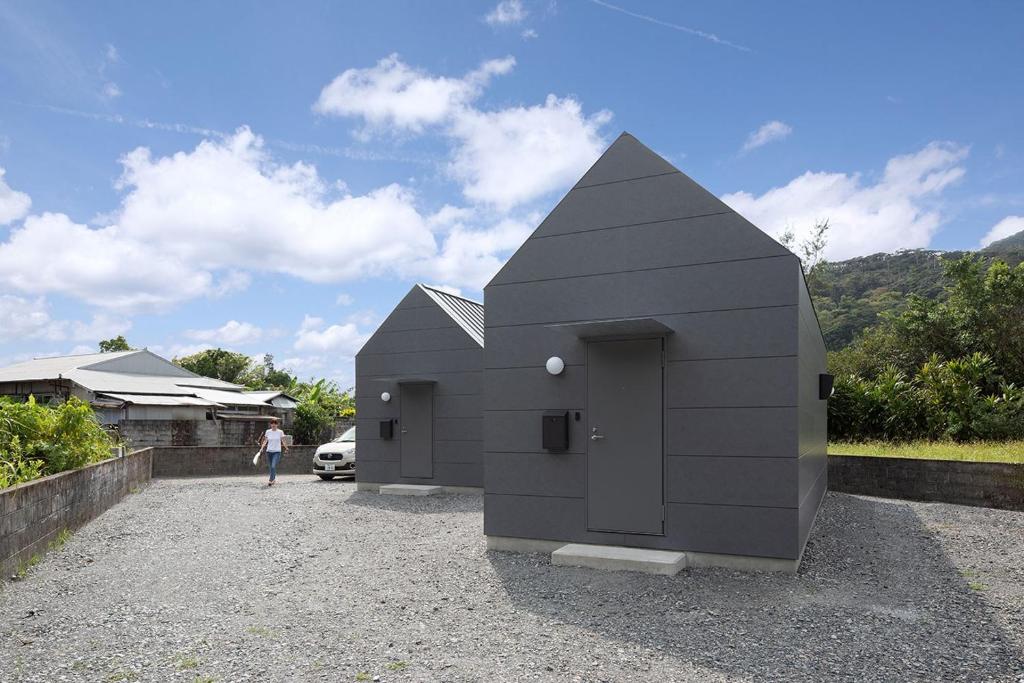 un pequeño edificio negro sentado en la parte superior de una entrada en match guest house（まっちゲストハウス）, en Tatsugo