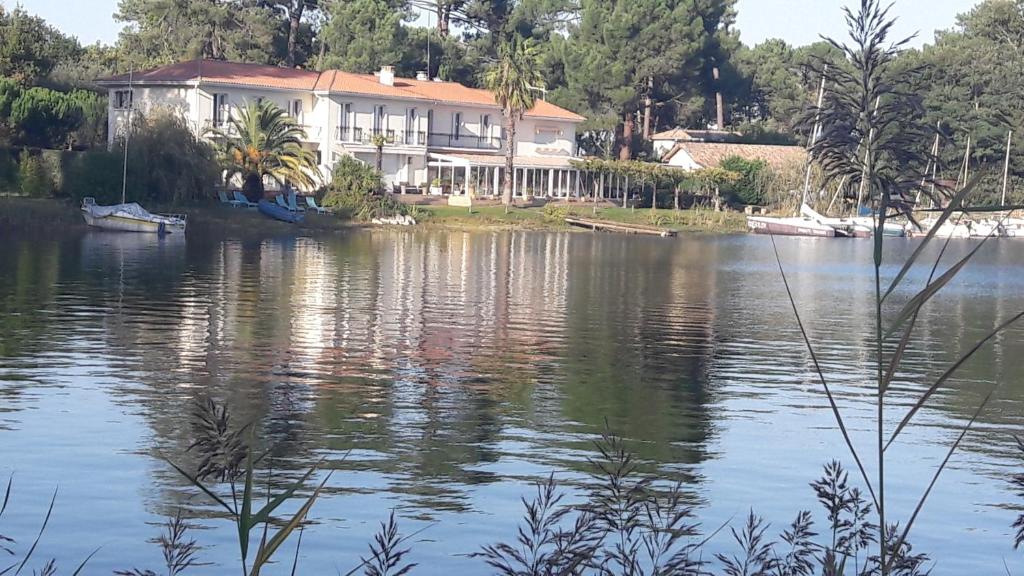 une maison sur la rive d'une masse d'eau dans l'établissement La Caravelle Logis, à Biscarrosse