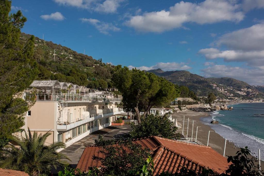 een uitzicht op een strand met gebouwen en de oceaan bij Matteo's House Taormina in Taormina
