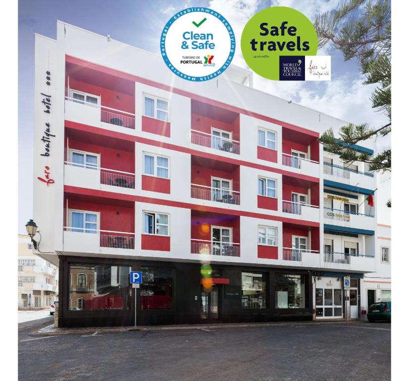 a red and white building with a sign that reads gate travels at Faro Boutique Hotel in Faro
