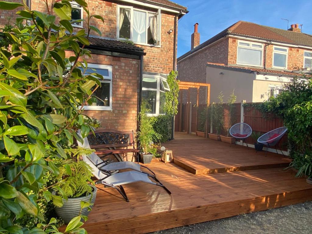 a wooden deck with two chairs on a house at Luxury 5* Home with Secret Garden and Free Parking in Liverpool