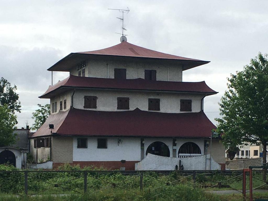 un edificio con una torre con tetto rosso di Hotel Cambogia a Zibido San Giacomo