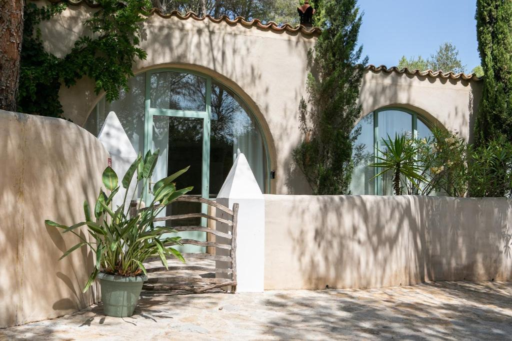 a house with a fence and a potted plant at Casa Los Arcos at Masia Nur Sitges, Adults only in Canyelles