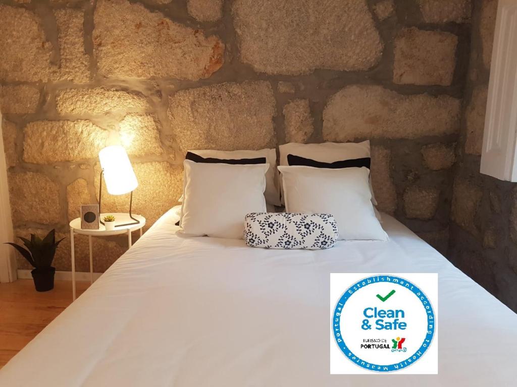 sypialnia z łóżkiem z kamienną ścianą w obiekcie Oporto Foz House close to the beach w Porto