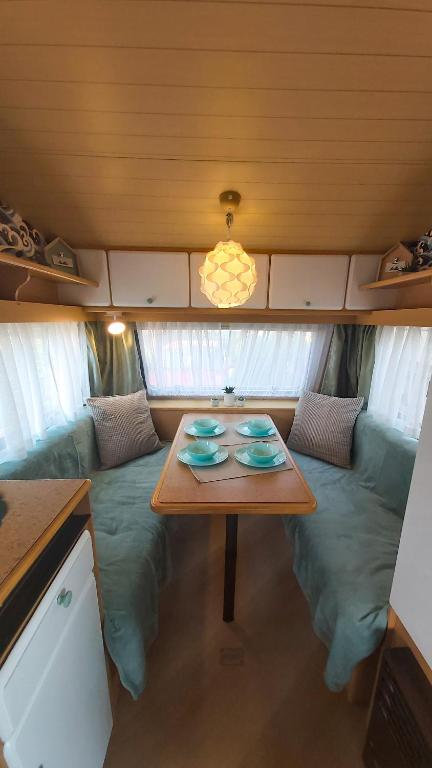 a table in the back of a trailer with a couch at Surf Przyczepa Jastarnia in Jastarnia