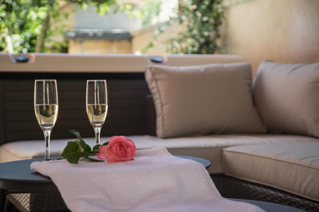 einen Tisch mit zwei Weingläsern und einer Rose drauf in der Unterkunft Apartmani M&C in Fažana