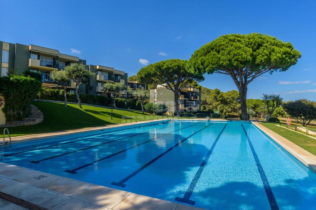 an empty swimming pool with trees and buildings at C-5 CALELLA DE PALAFRUGELL 5 PAX in Calella de Palafrugell