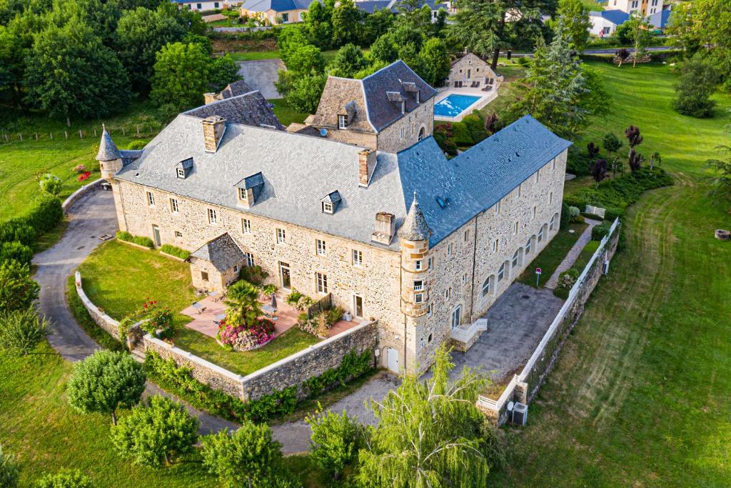 una vista aérea de una gran casa de piedra con patio en Château de la Falque, The Originals Relais (Relais du Silence), en Saint-Geniez-dʼOlt