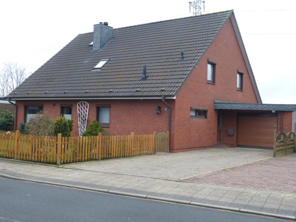 a red brick house with a wooden fence at Ferienwohnung Lorenzen in Husum