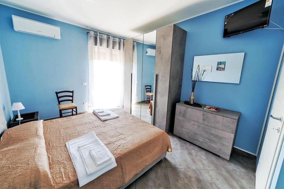 een blauwe kamer met een bed en een televisie bij Etna - Monte - Mojo in Moio Alcantara