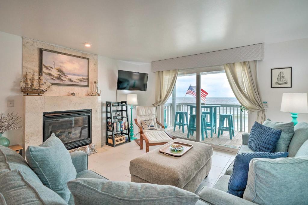 a living room with a couch and a fireplace at Ocean Dunes Kure Beach Condo with Balcony and Pool in Kure Beach