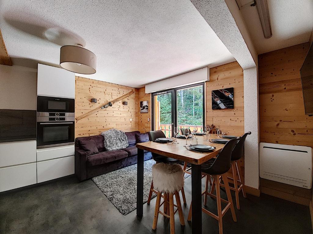 une cuisine et un salon avec une table et des chaises dans l'établissement MAGNIFIQUE APPARTEMENT REFAIT à NEUF - CALME - 2 Chambres - 6 Personnes - Vue Montagne GRAND CERF 65, à Saint-Jean-dʼAulps