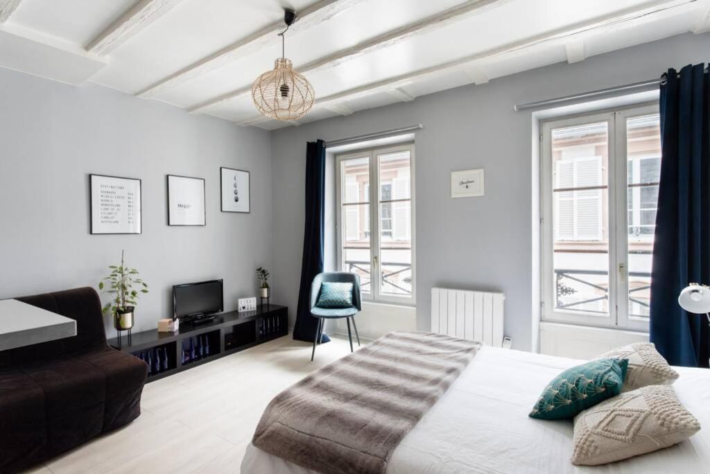 - une chambre avec un lit, un canapé et des fenêtres dans l'établissement R-Appartements Strasbourg La Petite Strasbourgeoise Hygge studio cosy, à Strasbourg
