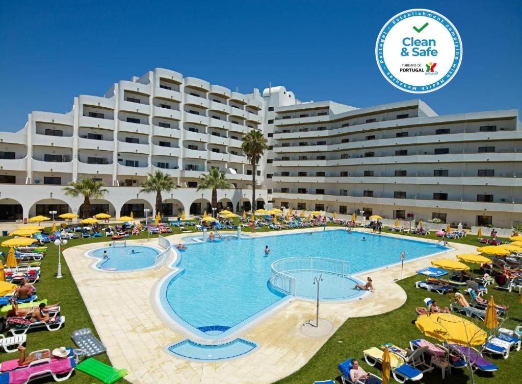 um grande hotel com piscina e um grande edifício em Hotel Apartamento Brisa Sol em Albufeira