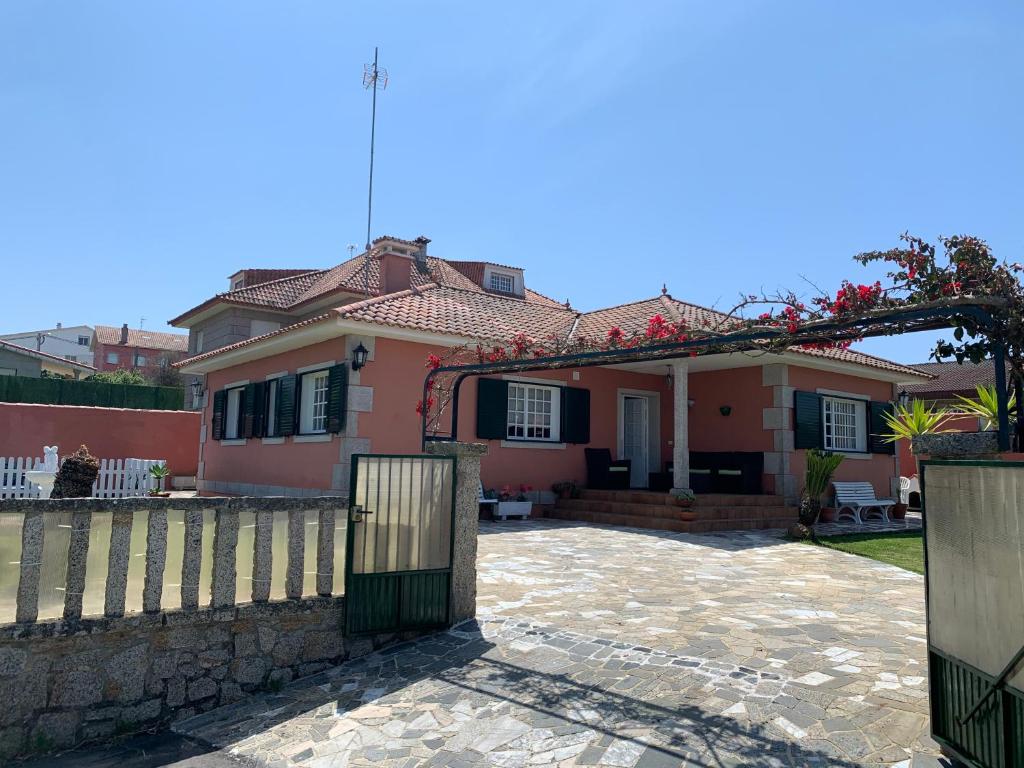 uma casa cor-de-rosa com um portão e uma vedação em Casa De Bascuas em Pontevedra