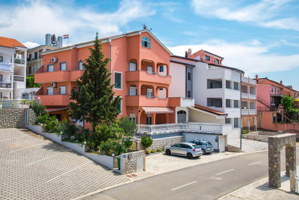 an apartment building with a car parked in front of it at Apartments Mikanović in Crikvenica