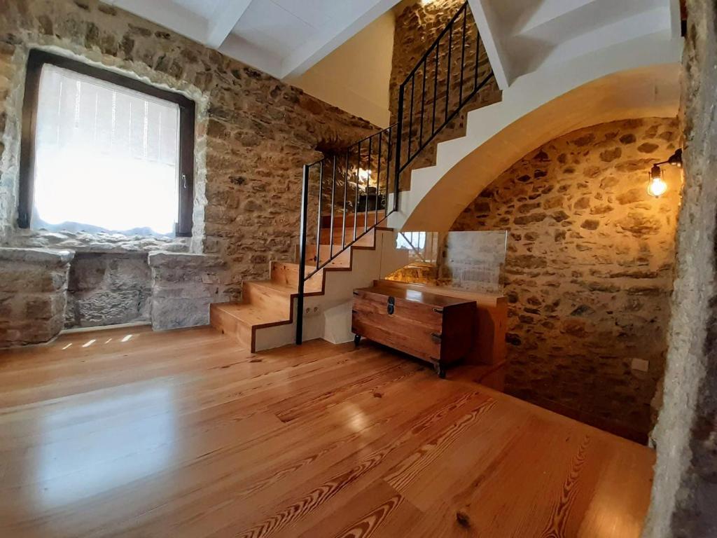 um quarto amplo com uma escada e uma parede de tijolos em MONELLS - CASA Rural - CAN FELIP em Monells