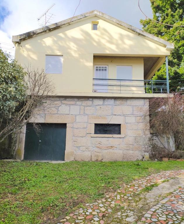 a house with a garage in front of it at Casa da Quinta in Covilhã