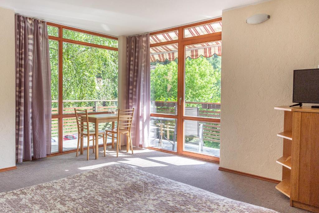 a bedroom with a table and chairs and a large window at Nerija in Nida