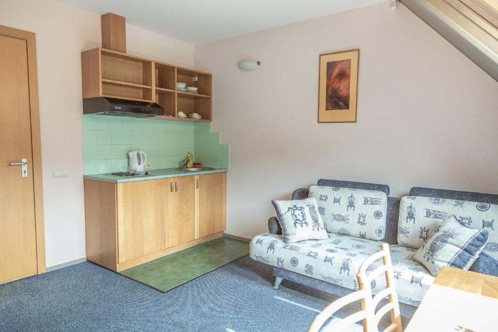 a living room with a couch and a kitchen at Nerija in Nida