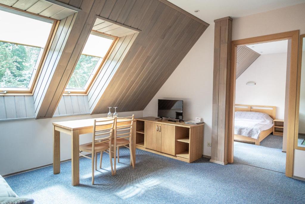 a room with a desk and a bed and a bedroom at Nerija in Nida