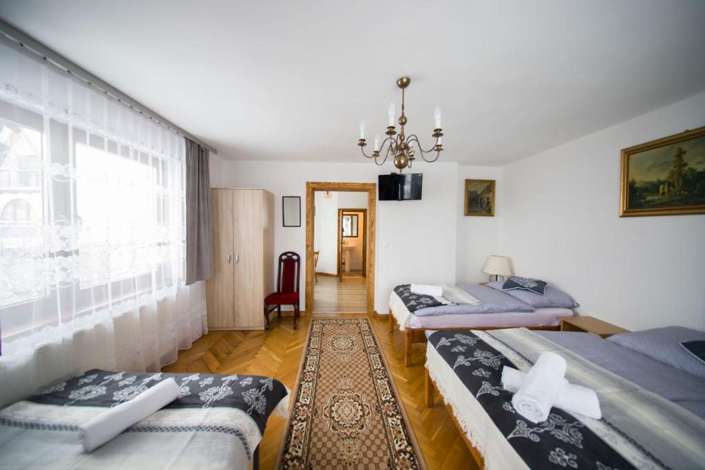 a room with two beds and a chandelier at Apartamenty Harenda 39 in Zakopane