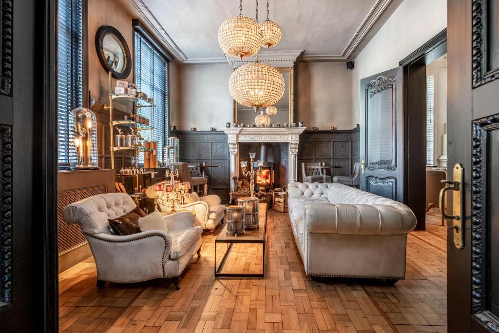 a living room with couches and a fireplace at Castelsuites in Bruges