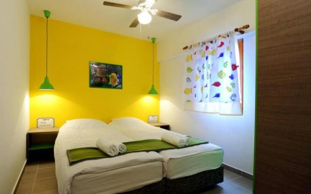 a bedroom with a bed with a yellow wall at Apartments Mizo in Ohrid