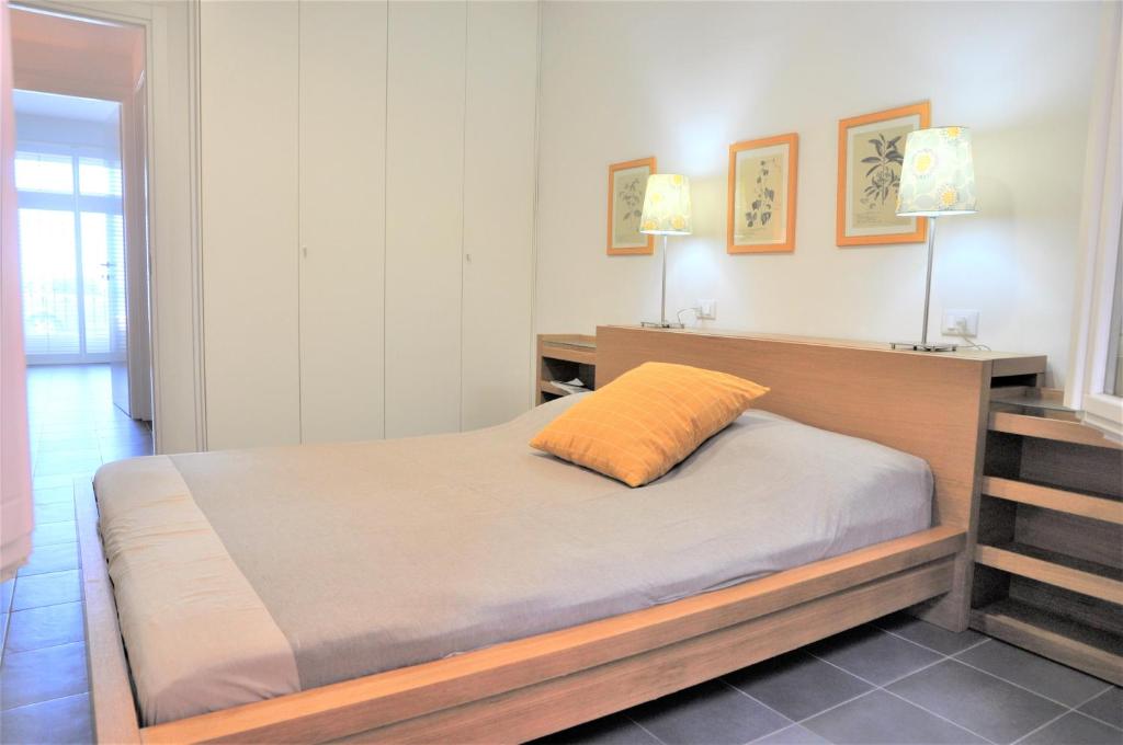 Schlafzimmer mit einem Bett mit orangefarbenem Kissen in der Unterkunft La Palma vacanze in riva al mare in Diano Marina