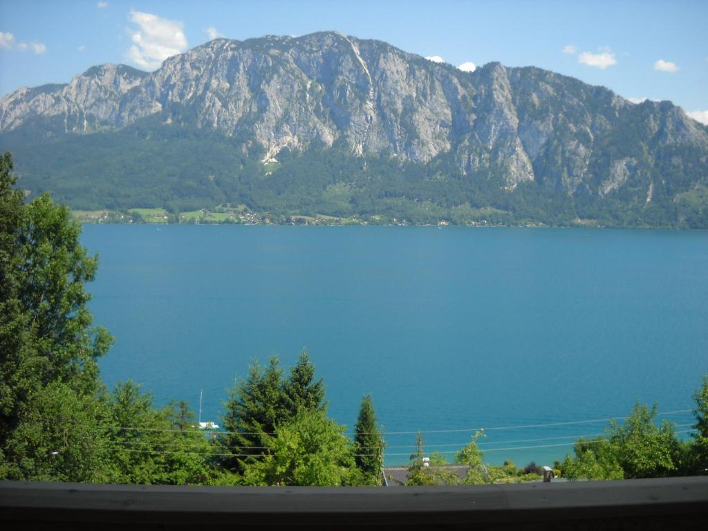 a large blue lake with a mountain in the background at Pension Christina in Unterach am Attersee
