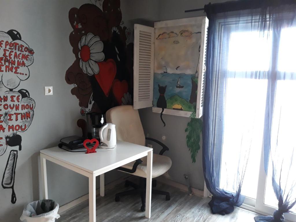 une table et une chaise dans une chambre avec fenêtre dans l'établissement The studio with the bohemian ambiance, à Thessalonique