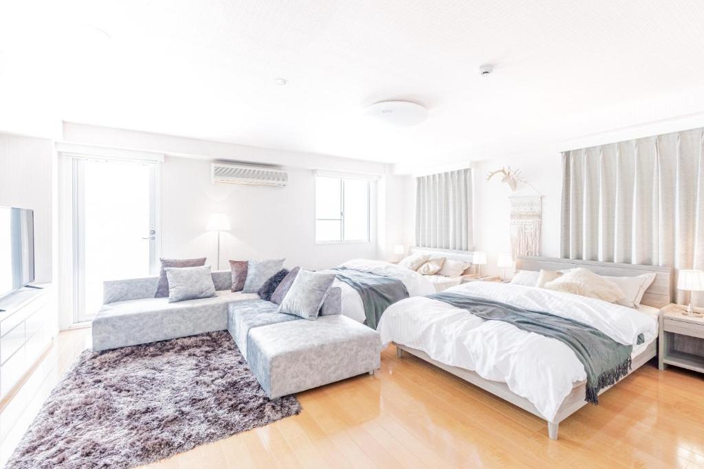 ein weißes Schlafzimmer mit 2 Betten und einem Sofa in der Unterkunft RESIDENCE HARIMAYAーVacation STAY82772 in Kōchi