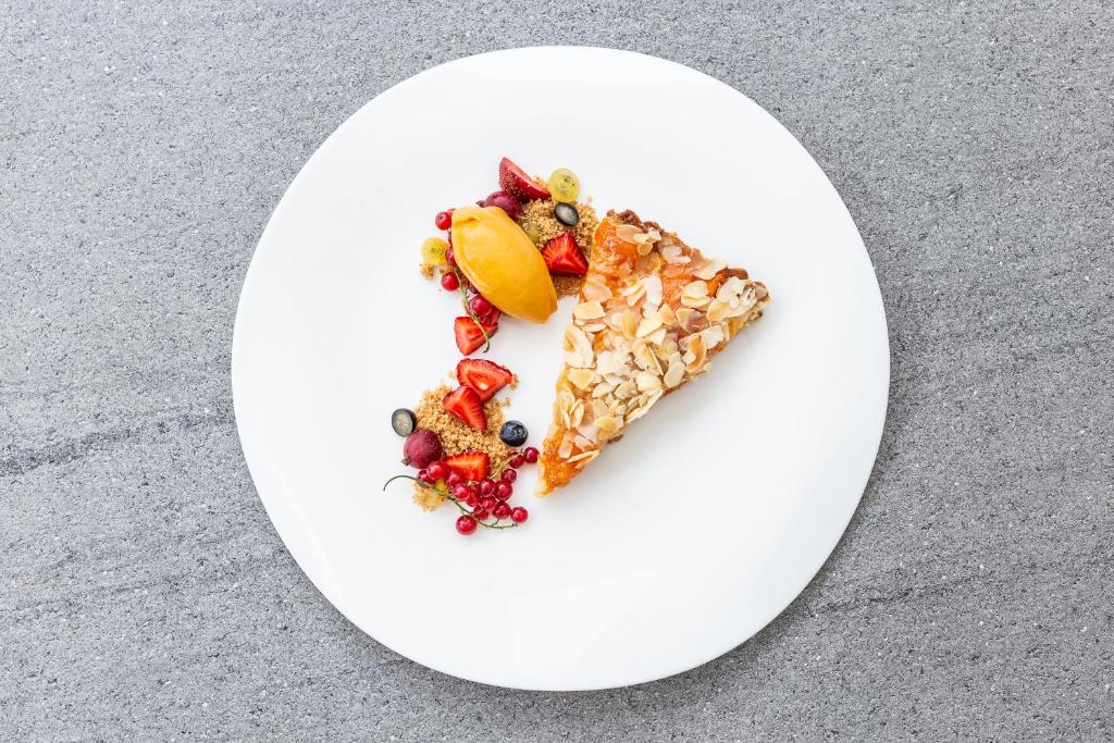 a piece of cake with fruit on a white plate at Nerija in Nida