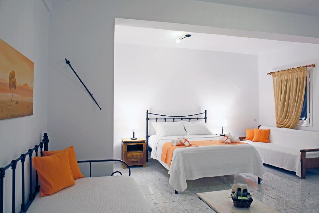 sypialnia z 2 łóżkami i kanapą w obiekcie Agistri Apartments w mieście Skala