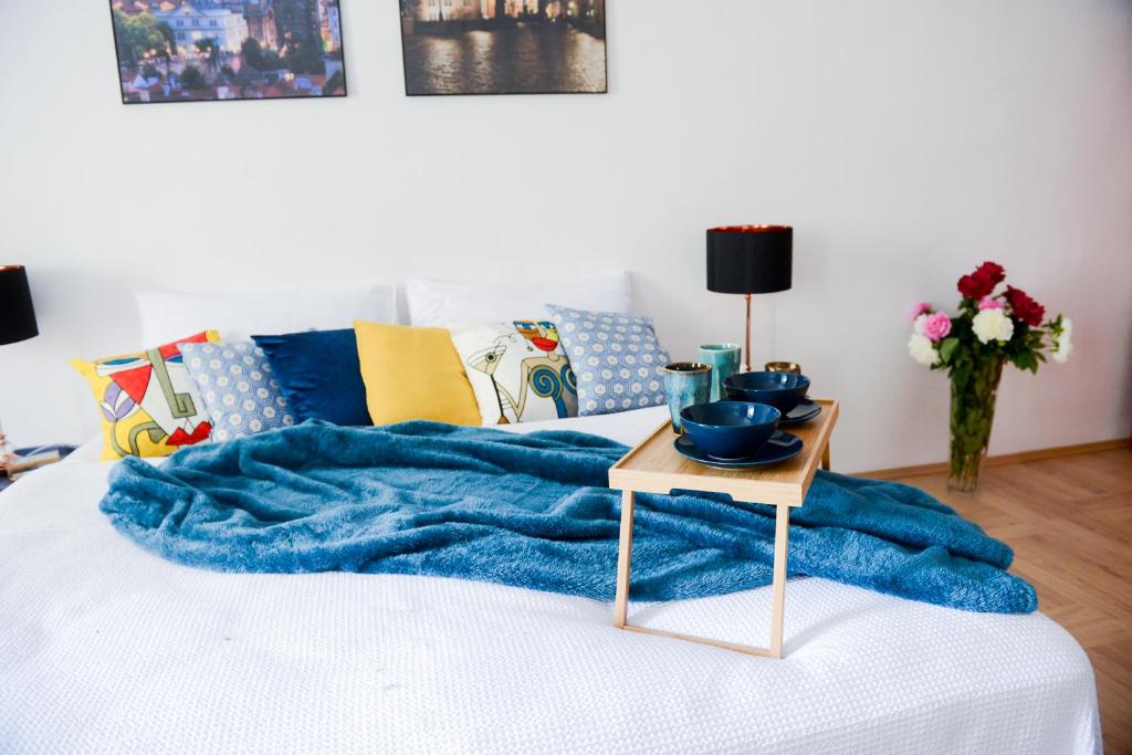 - un lit avec une couverture bleue et une table dans l'établissement Fano Apartments Old Town Prague, à Prague