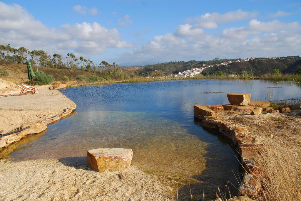 un cuerpo de agua con rocas en el agua en Montes de Baixo, en Odeceixe